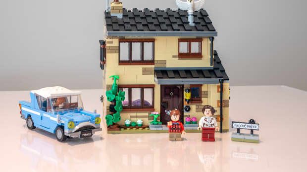 A completed Lego set of a house, two people, and a car