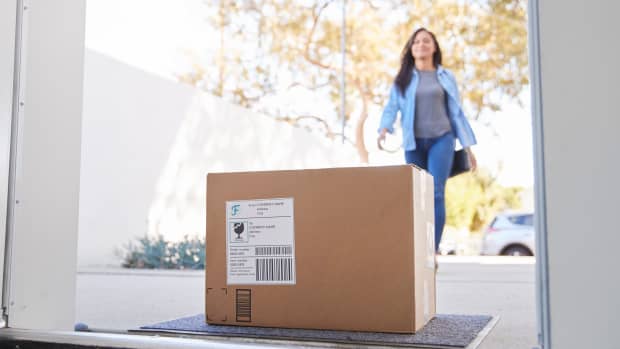 Woman approaches package on doorstep.