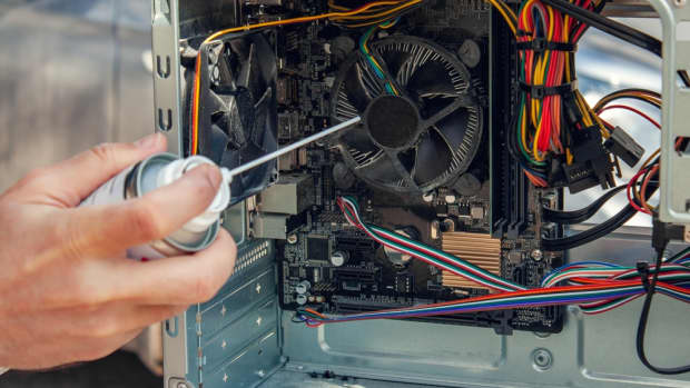 Man cleaning gaming PC with compressed air