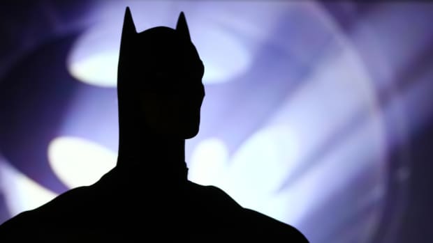 Batman in front of the Bat Signal
