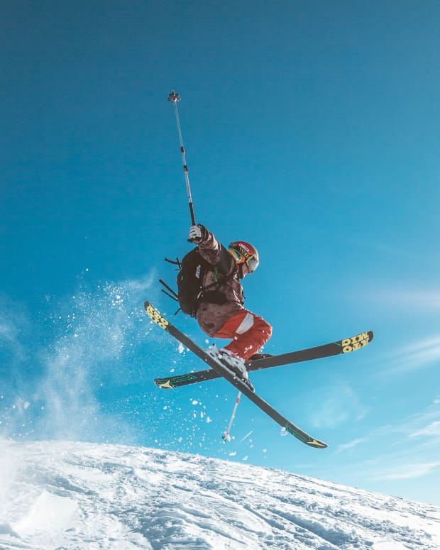 Skier in the air with blue sky.