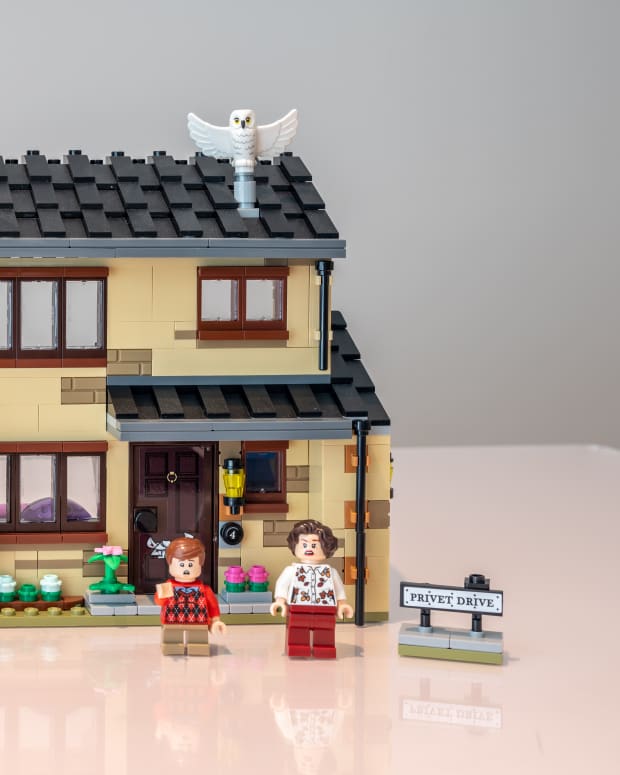 A completed Lego set of a house, two people, and a car