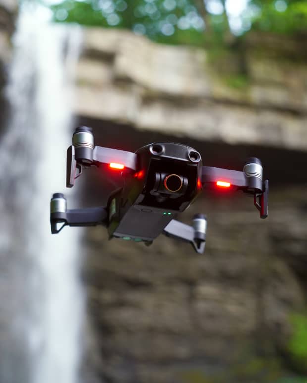 Drone in air by waterfall.